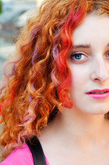 Young beautiful woman with red hair and colorful hair chalk