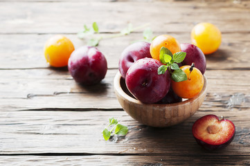 Sweet fresh black and yellow plums on the table