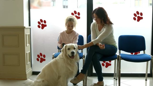 Mother and daughter with dog in vet waiting room