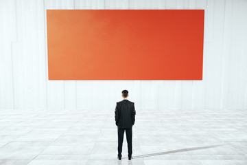 Obraz premium Businessman looking at red billboard