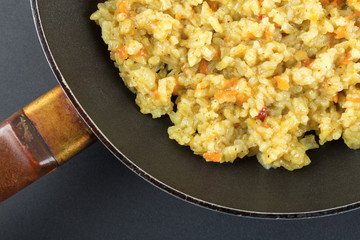 Boiled rice in a frying pan on a black