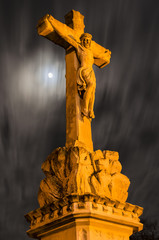 Statue of the crucified Christ on a full moon