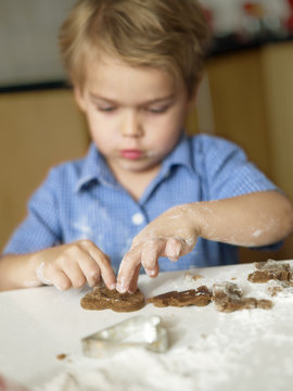 Boy (6-7) making cookies in kitchen