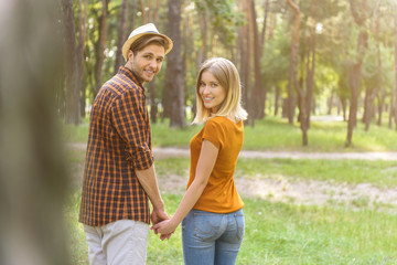 Fototapeta premium Joyful guy and girl walking in nature