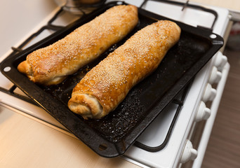 Traditional apple strudel pie with sesame on baking pan