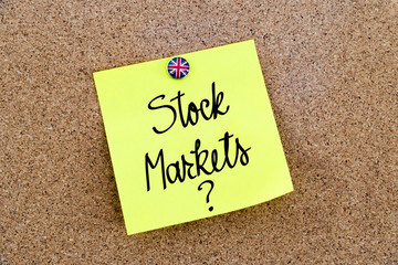 Yellow paper note pinned with Great Britain flag thumbtack and text STOCK MARKETS ?