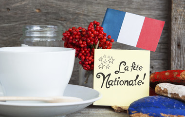 The National Celebration In France La fete nationale (Bastille Day) - text, Heart shaped cookies color red, blue, white. Cup of coffee (tea), france flag, decoration. Patriotic Breakfast Concept.