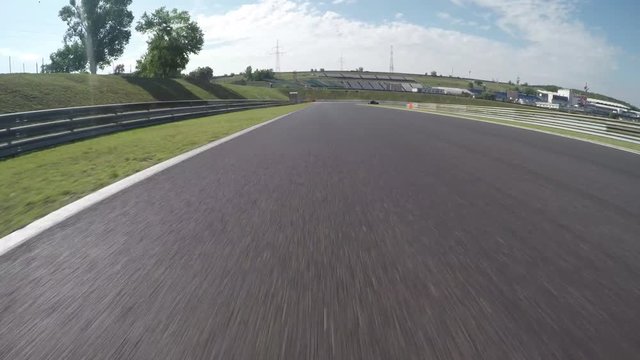 LOW ANGLE VIEW: Race car competing and driving fast on race track lap