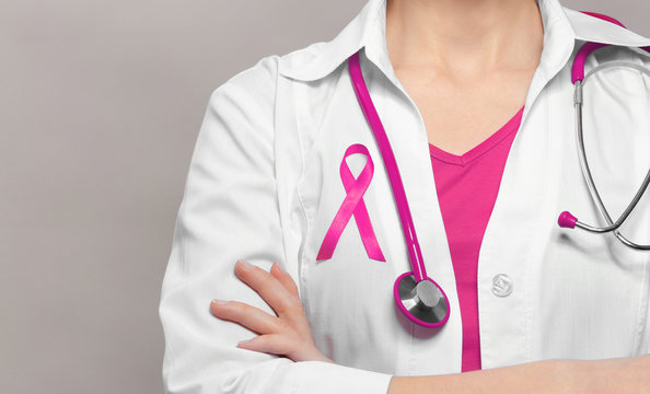 Female Doctor With Pink Ribbon. Cancer Concept