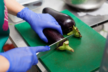 are cutting eggplants on the board