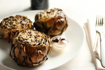 Baked artichokes with cheese on white plate