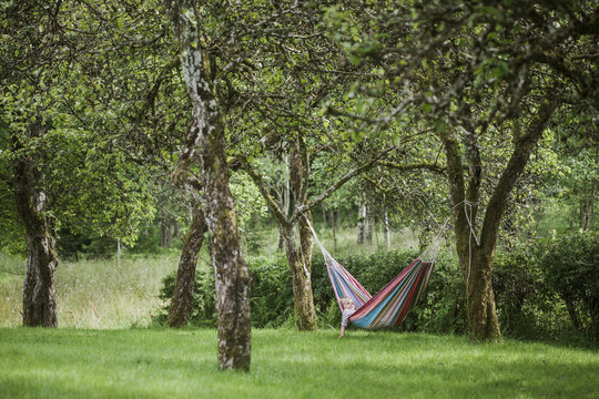 Girl lying in hammock at garden