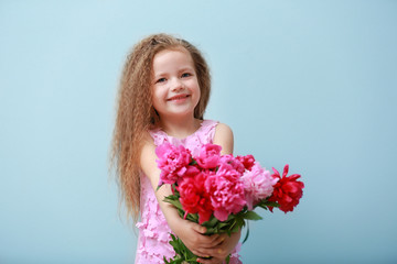 Girl holding fresh peonies bouquet on blue background