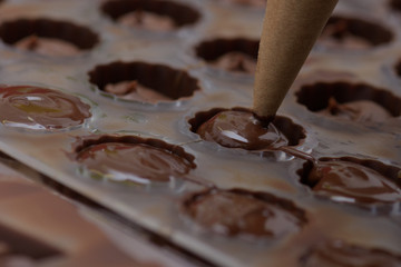 Pouring chocolate into metal molds