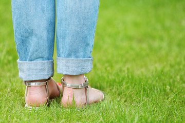 Female feet in sandals on green grass