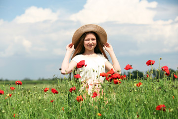 Obraz na płótnie Canvas Beautiful girl in poppy field