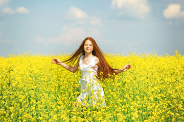 Naklejka na ściany i meble Sweet girl in meadow with wild spring flowers