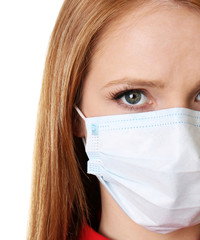 Red-haired girl with a medical mask on a white background