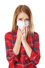 Red-haired girl with a medical mask on a white background