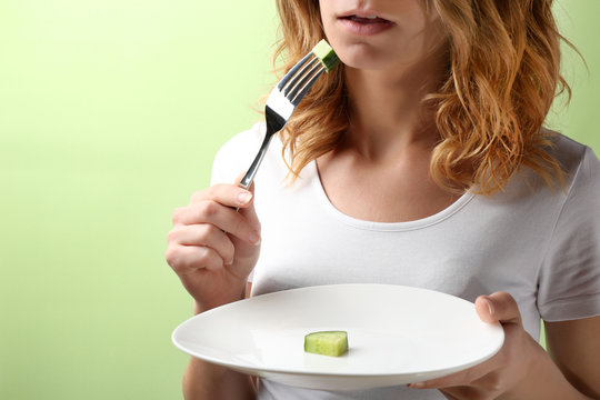 Woman on diet eating cucumber