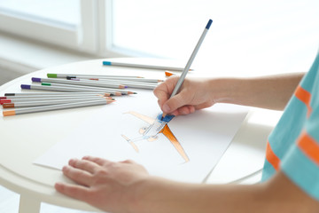 Child's hand drawing picture on paper