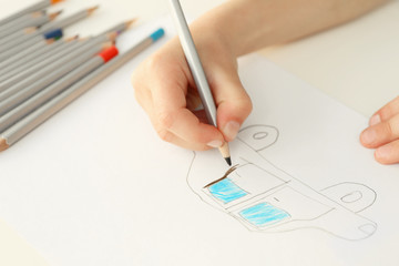 Child's hand drawing picture on paper