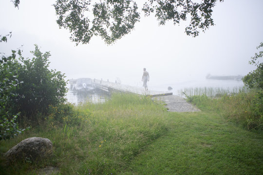 Rear view of man walking on dock