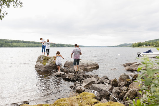 Sweden, Vastmanland, Bergslagen, Hallefors, Nygard, Family with four children (18-23 months, 10-11, 12-13, 14-15) standing on rocks