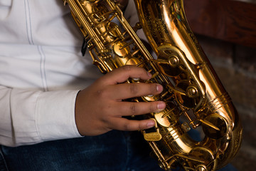 Young gypsy saxophone player.Colored and under exposed photo