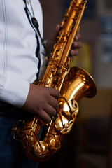 Obraz premium Young gypsy saxophone player.Colored and under exposed photo