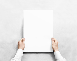 Hand holding white blank poster mockup, isolated. Arm in shirt hold clear broadsheet template mock...