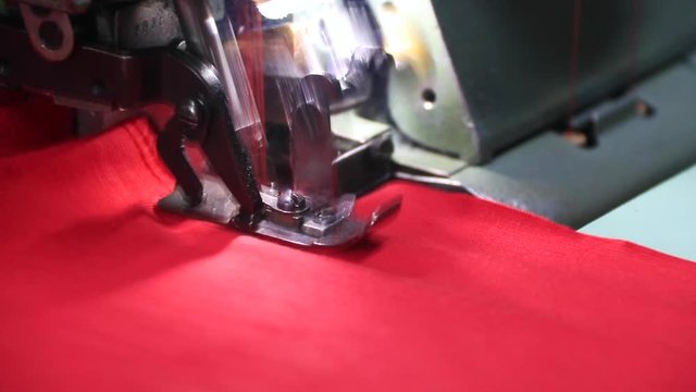 Professional overlock sewing machine with red fabric