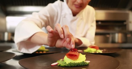 Smiling chef finalizing dishes in the kitchen - Powered by Adobe