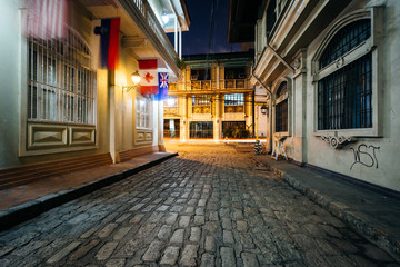Fototapeta na wymiar A cobblestone street at night, in Intramuros, Manila, The Philip