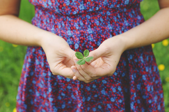 Finland, Helsinki, Aggelby, Mid section shot of woman holding four-leaf clover