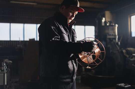 Sweden, Teenage boy (16-17) winding wire on spool