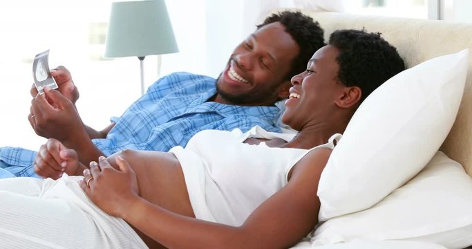 Happy pregnant couple looking at an ultrasound
