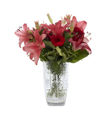 Red and pink lilies in a crystal vase isolated on white background