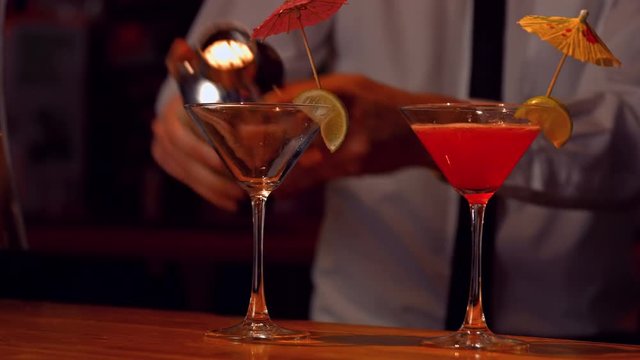 Bartender pouring cocktails on counter in high quality 4k format