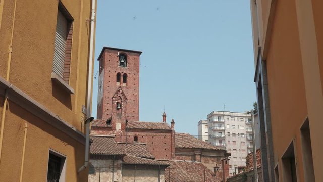 San Lorenzo church spire between residential buildings, Mortara, PV, Italy
