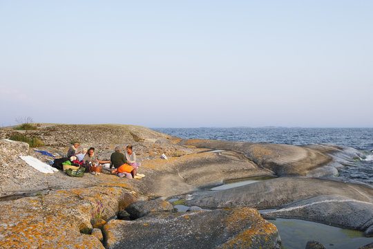 Sweden, Stockholms Archipelago, Sodermanland, Haninge, Norsten, People having picnic on rocks at seaside