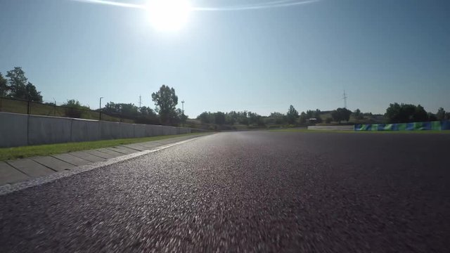LOW ANGLE VIEW: Race car competing and driving fast on race track lap
