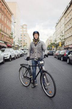 Sweden, Sodermanland, Stockholm, Sodermalm, Hornstull, Mid adult man standing by his bicycle on street