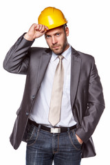 A man in a suit with yellow safety helme.