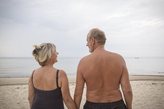 Senior couple together standing on beach