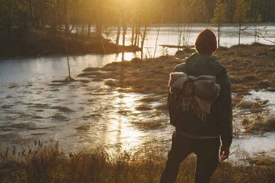 Finland, Esbo, Kvarntrask, Young man standing on marshy lakeshore