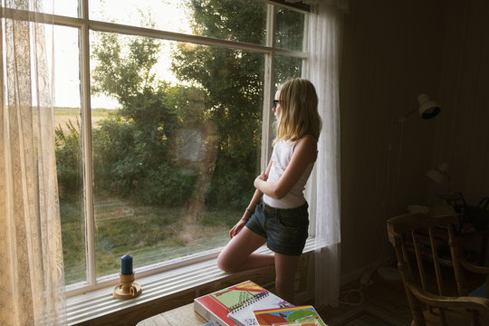 Sweden, Skane, Vejbystrand, Girl (10-11) looking though window