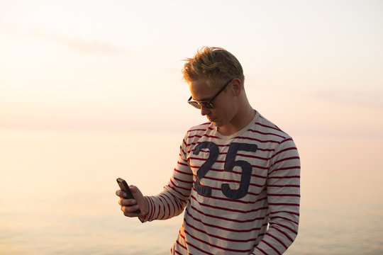 Young man using smartphone while standing outdoors