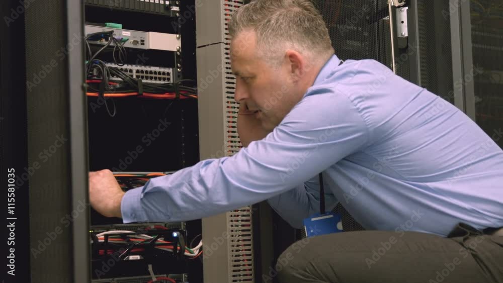 Poster technician using laptop to analyse server