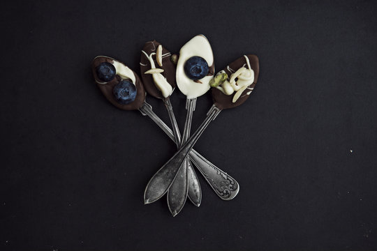 Spoons with chocolate over black background
